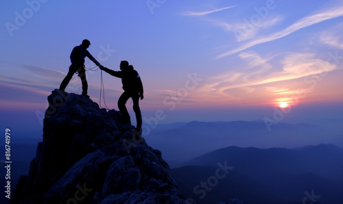 Silhouettes of two people climbing on mountain and helping. Teamwork of two men hiker helping each other on top of mountain climbing team beautiful sunrise. Help and assistance concept.