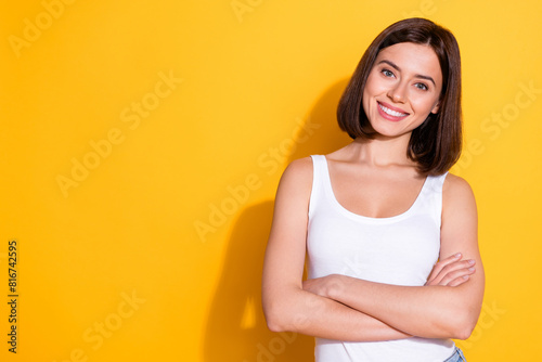 Photo portrait of attractive young girl crossed hands confident wear trendy white outfit isolated on yellow color background