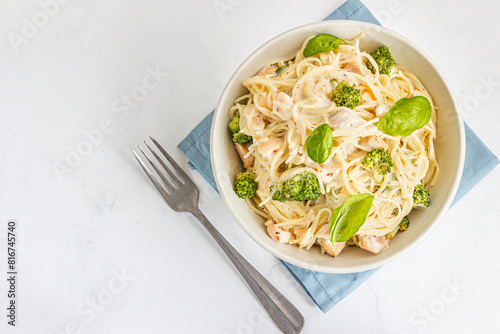 Creamy Chicken Spaghetti with Broccoli in a Bowl Garnished with Fresh Basil Leaves Top Down Photo