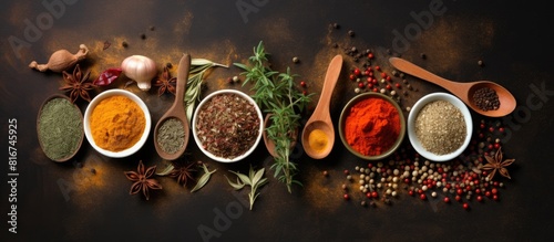 Top view of various bowls and spoons filled with vibrant dry spices placed alongside ginger garlic and rosemary on a white background with ample copy space for additional elements