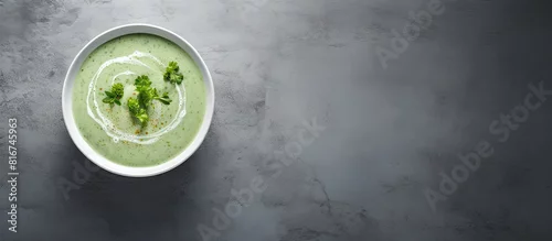 Panel kuchenny z motywem This is a top down view of a vegan cream soup made from green vegetables served in a grey bowl on a grey background In the image there is a panoramic view with copy space