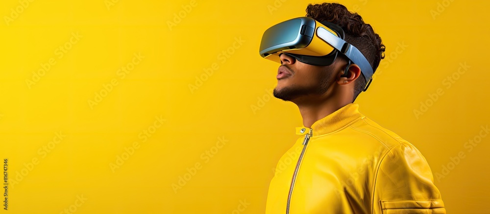 A young man wearing a virtual reality headset is shown against a vibrant yellow background offering ample room for adding text or graphics A young man wearing a virtual reality headset is shown against a vibrant yellow background offering ample room for adding text or graphics