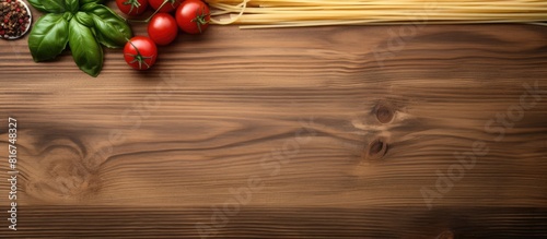 Top view of spaghetti with basil tomatoes and cheese on a wooden background providing ample copy space for text