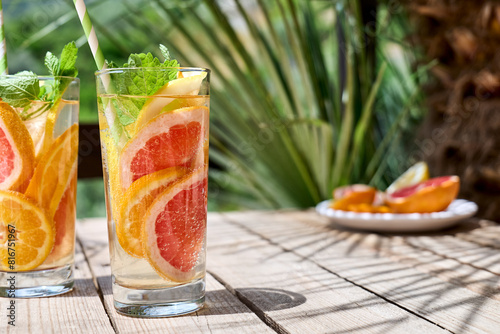 Summer refreshing lemonade drink with grapefruit, lemon, orange slices and mint. Fresh healthy cold citrus beverage. Citrus fruit infused water.