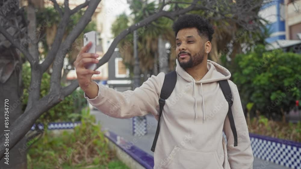 African-american man taking a selfie with smartphone outdoors in the city. African-american man taking a selfie with smartphone outdoors in the city.