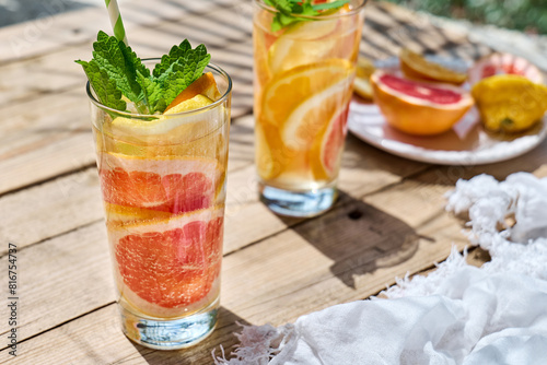 Summer refreshing lemonade drink with grapefruit, lemon, orange slices and mint. Fresh healthy cold citrus beverage. Citrus fruit infused water.