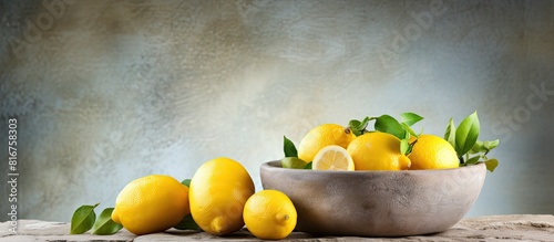 Organic lemons in a bowl on stone background with copy space