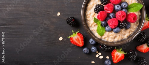 A fresh and healthy meal of oatmeal porridge with chia seeds and berries is displayed on a table creating a vibrant and appetizing food background with copy space image photo