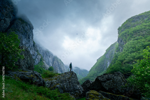 Atmospheric Contemplation: Man Overlooking Moody Norwegian Fjord photo