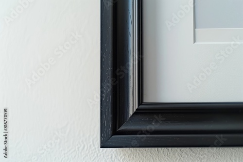 Close-up of a sleek black framed picture hanging on a white wall