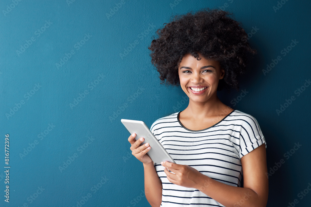African woman, tablet and smile in studio portrait with space for mock up with study on app by blue background. Person, girl and click on digital touchscreen, online course or elearning for education African woman, tablet and smile in studio portrait with space for mock up with study on app by blue background. Person, girl and click on digital touchscreen, online course or elearning for education