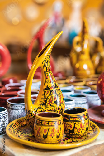 Close-up of a beautifully crafted Cappadocian pottery set, yellow pitcher with intricate designs and matching cups. Nevsehir, Cappadocia, Turkey (Turkiye)
