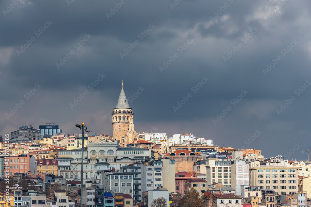 Dramatic view of Istanbul's skyline with the iconic Galata Tower standing tall against a backdrop of dark, stormy clouds. Istanbul, Turkey (Turkiye) Dramatic view of Istanbul's skyline with the iconic Galata Tower standing tall against a backdrop of dark, stormy clouds. Istanbul, Turkey (Turkiye)