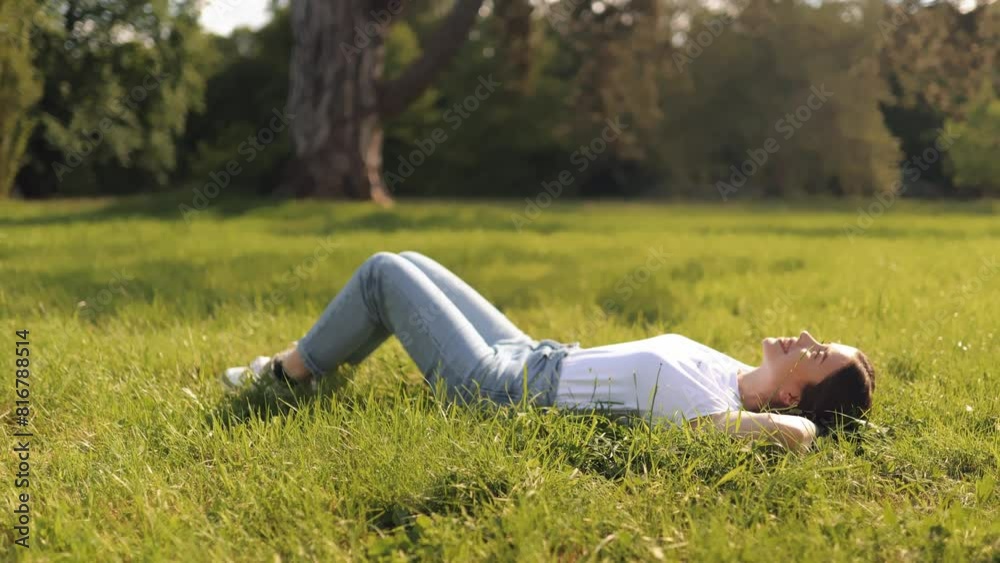 Young attractive woman girl lying in the grass and enjoying nature on a warm sunny summer day, tourist traveler Young attractive woman girl lying in the grass and enjoying nature on a warm sunny summer day, tourist traveler