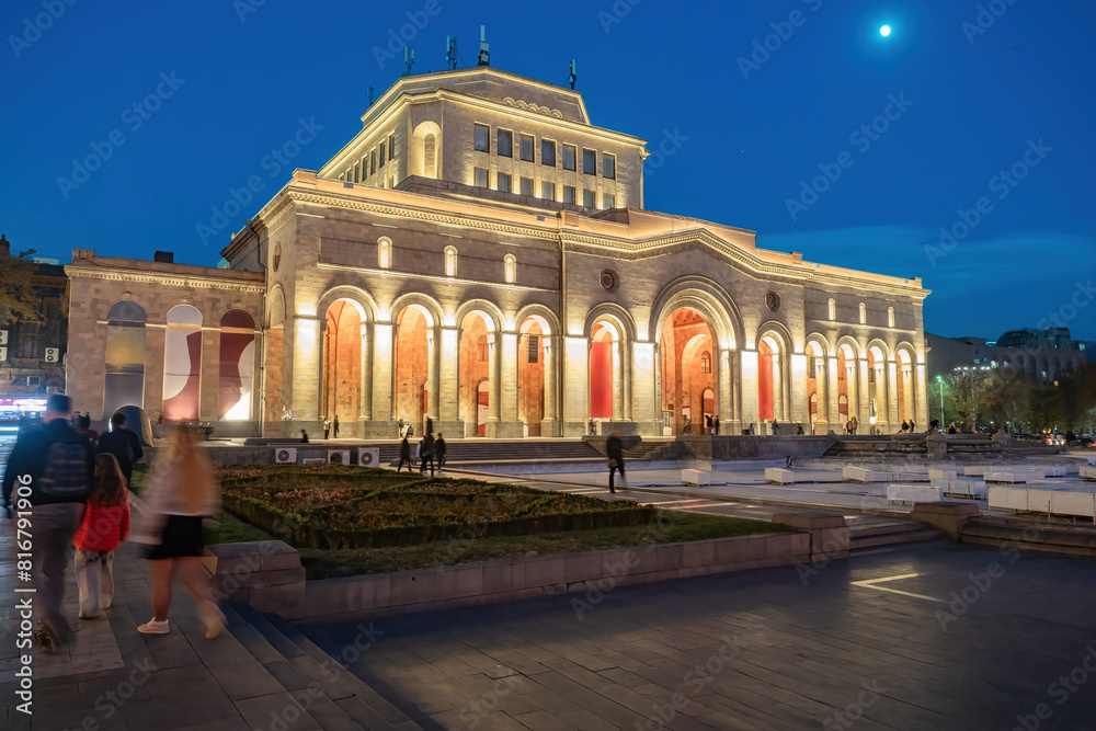 Fototapeta premium Museums of Armenia. Night Yerevan. Building national painting gallery Armenia. Republic square in Yerevan. Architecture south caucasus. Museum building with columns. People walk along streets Yerevan