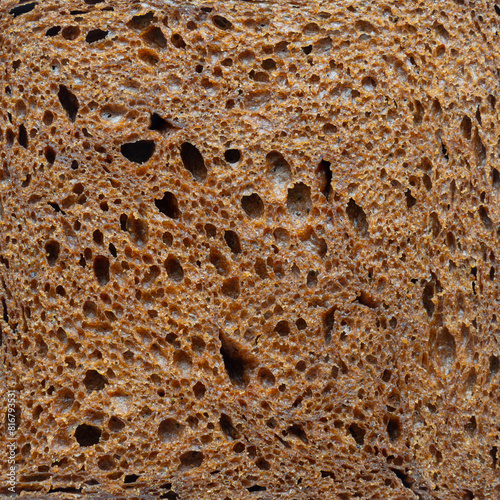 A close up of a piece of bread with holes in it. The bread is brown and has a rough texture
