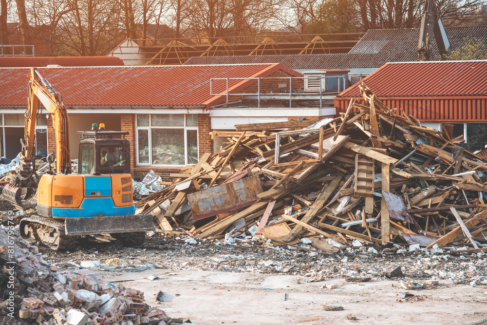 Fototapeta premium Demolition of building. Excavator breaks old house. 
