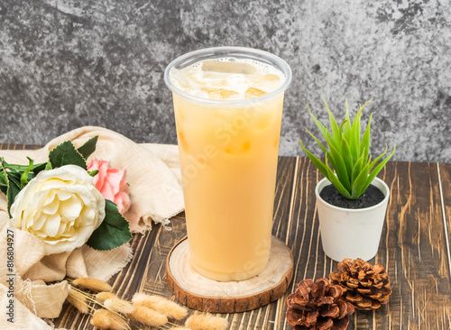 Iced Yakult Green Tea with ice cube served in disposable glass isolated n table side view of taiwanese drink photo