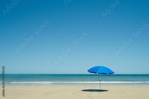 minimalist beach scene with solitary blue umbrella evoking tranquility and solitude against clear sky