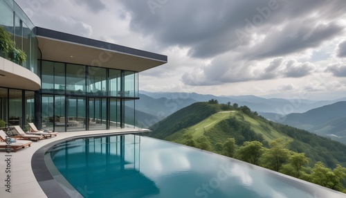 A modern, two-story glass and concrete house with a large swimming pool in the foreground, surrounded by a mountainous landscape
