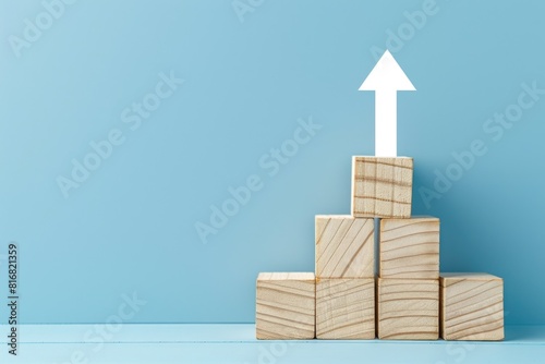 A stack of wooden blocks with an arrow pointing up. Suitable for business concepts