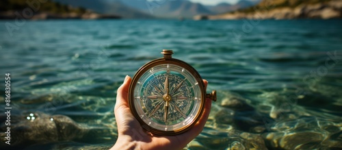 View of woman's hand with compass on beautiful sea landscape background photo