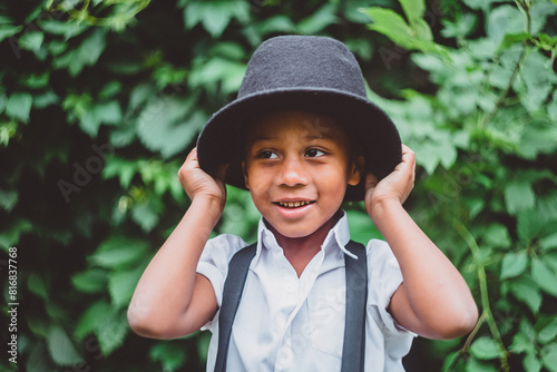 the boy smiles and puts a hat on his head