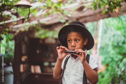 boy in hat playing harmonica on open veranda
