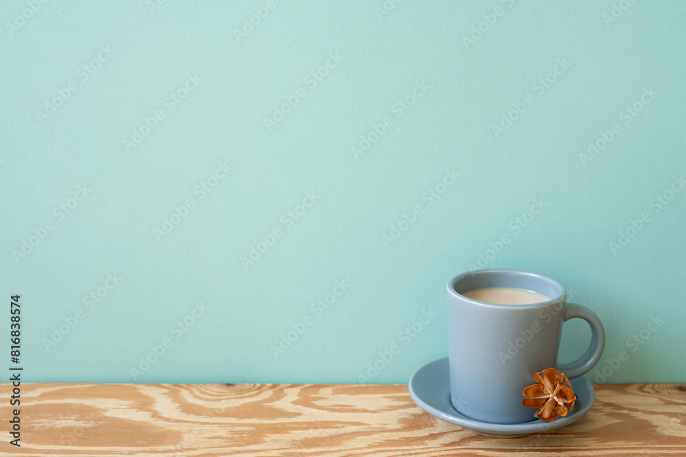 Cup of latte coffee on wooden table. mint wall background