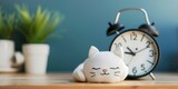 A cute cat is sleeping next to an alarm clock.