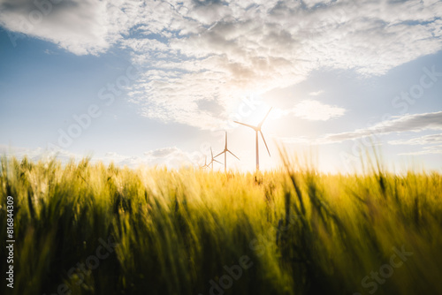 Wind turbines farm, wind power energy generation equipment, clean energy concept. Windmills in the sunlight. Renewable and green energy