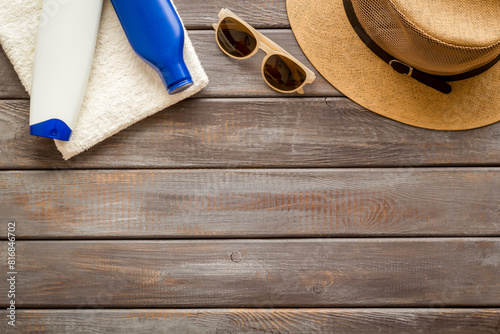 Summer holiday beach background. Male straw hat with sunscreen and sunglasses, top view