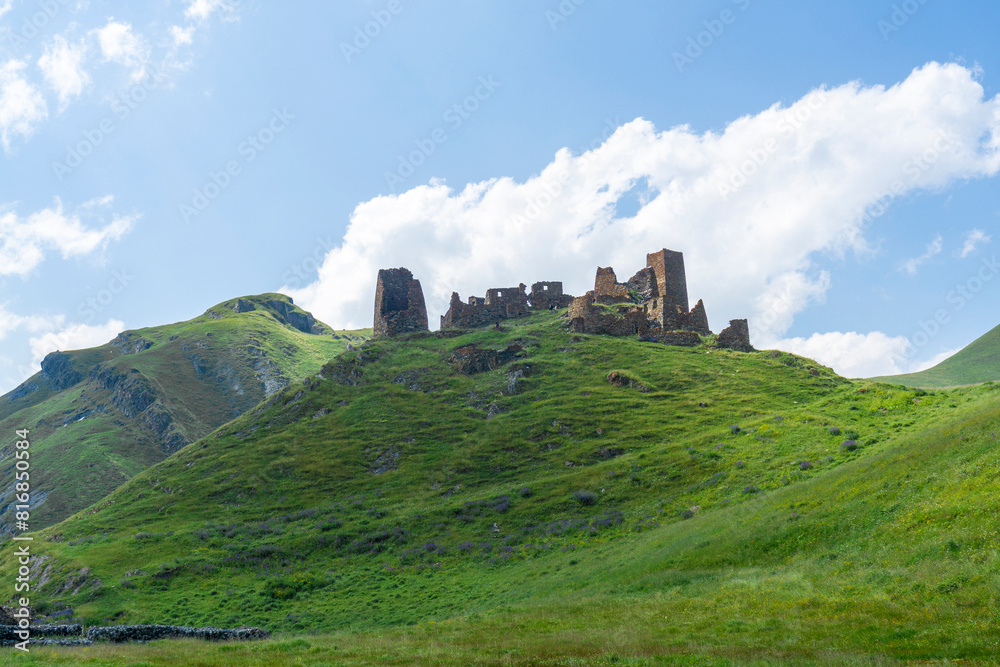 Zakagori fortress on the hill covered with grass. Mountains around