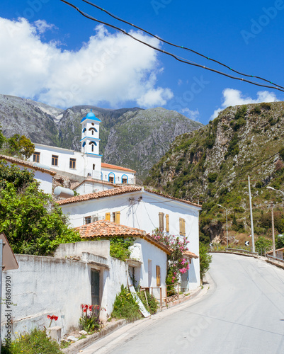 Dhermi Village - Dolce Vita, Flowered Houses, and Blue Bell Tower Against Mountains photo