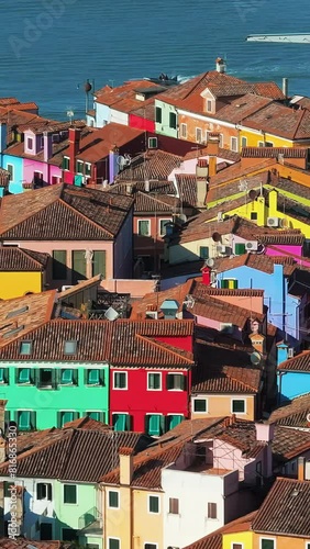 Aerial drone view of the colourful houses of Burano Island, Italy. Vertical photo