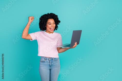 Photo portrait of lovely young lady hold netbook winning dressed stylish striped garment isolated on aquamarine color background © deagreez