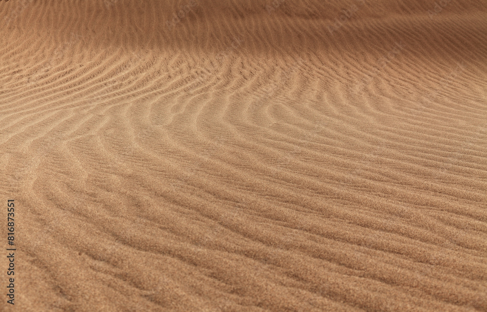 Naklejka premium natural sand pattern created by wind blowing differently sized and colored particles