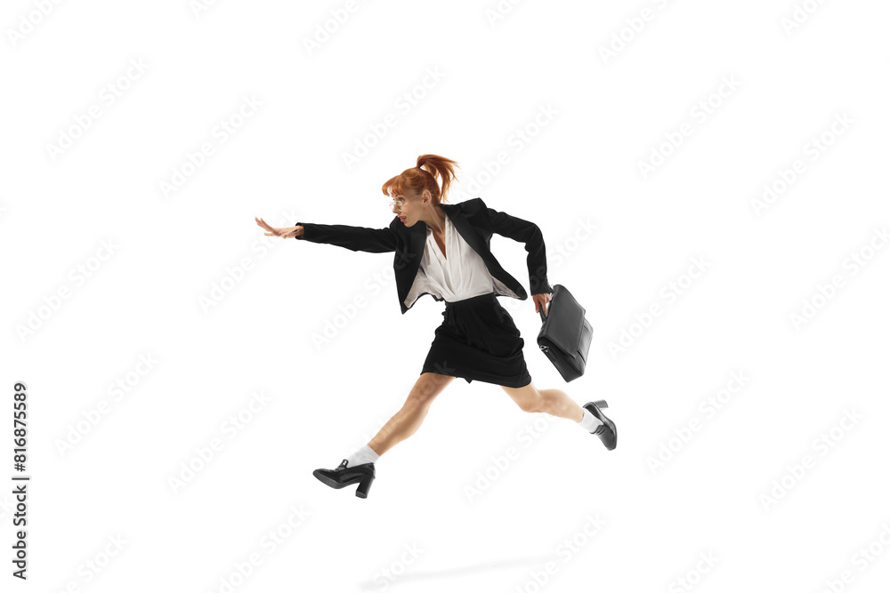 Ambitious young woman, employee on formal wear, with briefcase in dynamic pose, running forward isolated on white background. Reaching professional growth. Business, office lifestyle, success concept