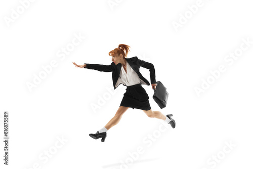 Ambitious young woman, employee on formal wear, with briefcase in dynamic pose, running forward isolated on white background. Reaching professional growth. Business, office lifestyle, success concept