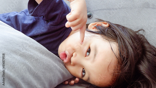 cute Asian toddler on the couch and making funny face