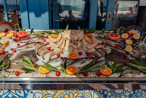 sea food on outside store counter. Fish and crab on ice decorated with fresh citrus fuit