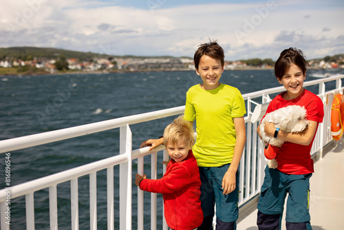Children, experience ride with ferry on a fjord, strong wind on the deck of the ferry on sunny day