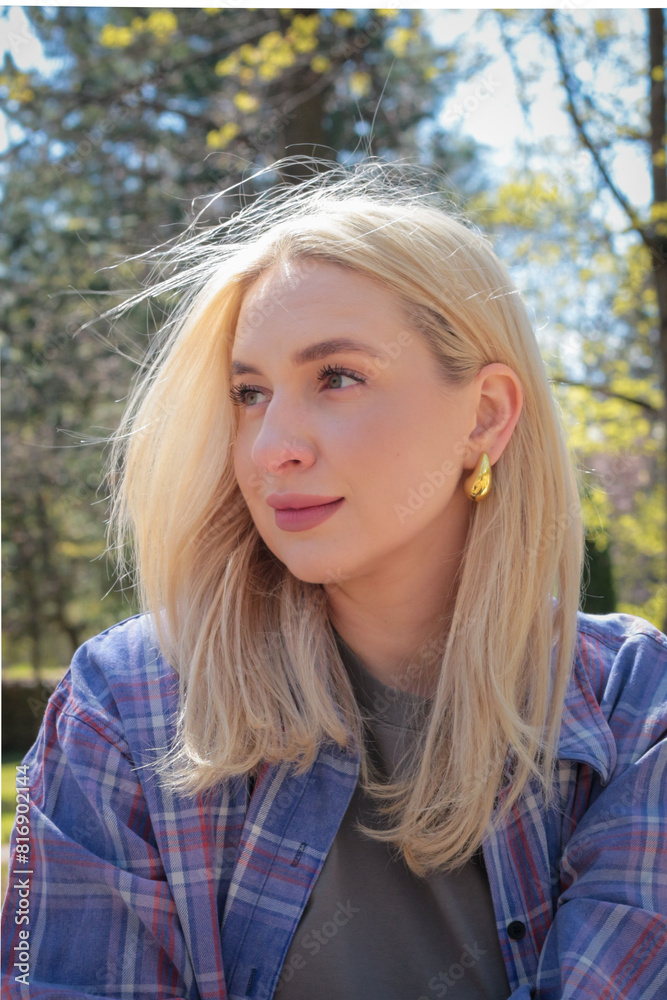 Naklejka premium Beautiful girl with blonde hair posing in the park