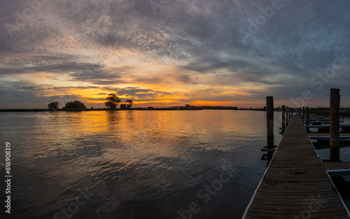 Boat dock on the delta in Northern California with colorful sky and clouds reflecting in the water