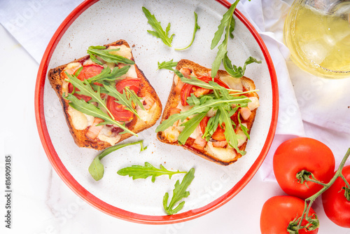 Tasty crunchy toasts pizza. Fast food, modern variation of portioned quick made pizza on toast bread with tomato, bacon, mozzarella cheese and arugula, copy space