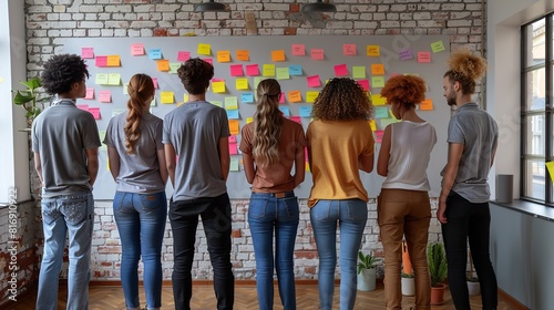 A diverse group of individuals standing in front of a wall covered in colorful sticky notes, engaging in collaborative brainstorming and idea sharing