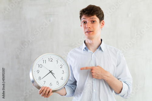 Young guy posing with clock in studio