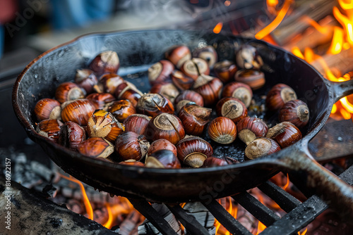 Cast iron pan filled with aromatic roasted chestnuts, evoking seasonal comfort and traditions photo