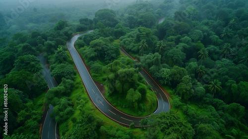 Aerial top view beautiful curve road on green forest in the rain season.
