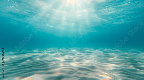 Sunlight Penetrating Clear Blue Water Revealing Sandy Ocean Floor with Gentle Ripples and Sparkling Waves